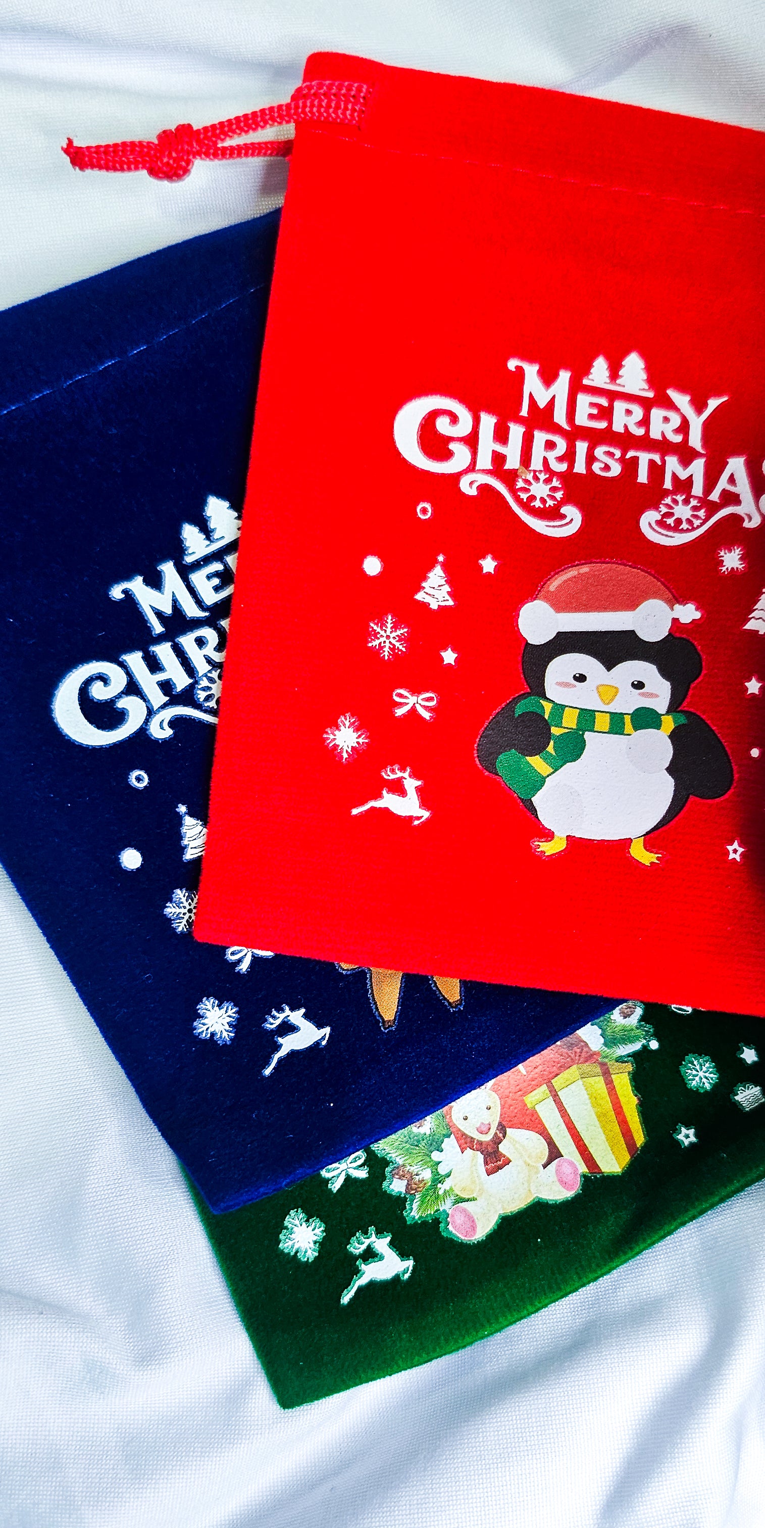 Three Christmas-themed drawstring bags 
