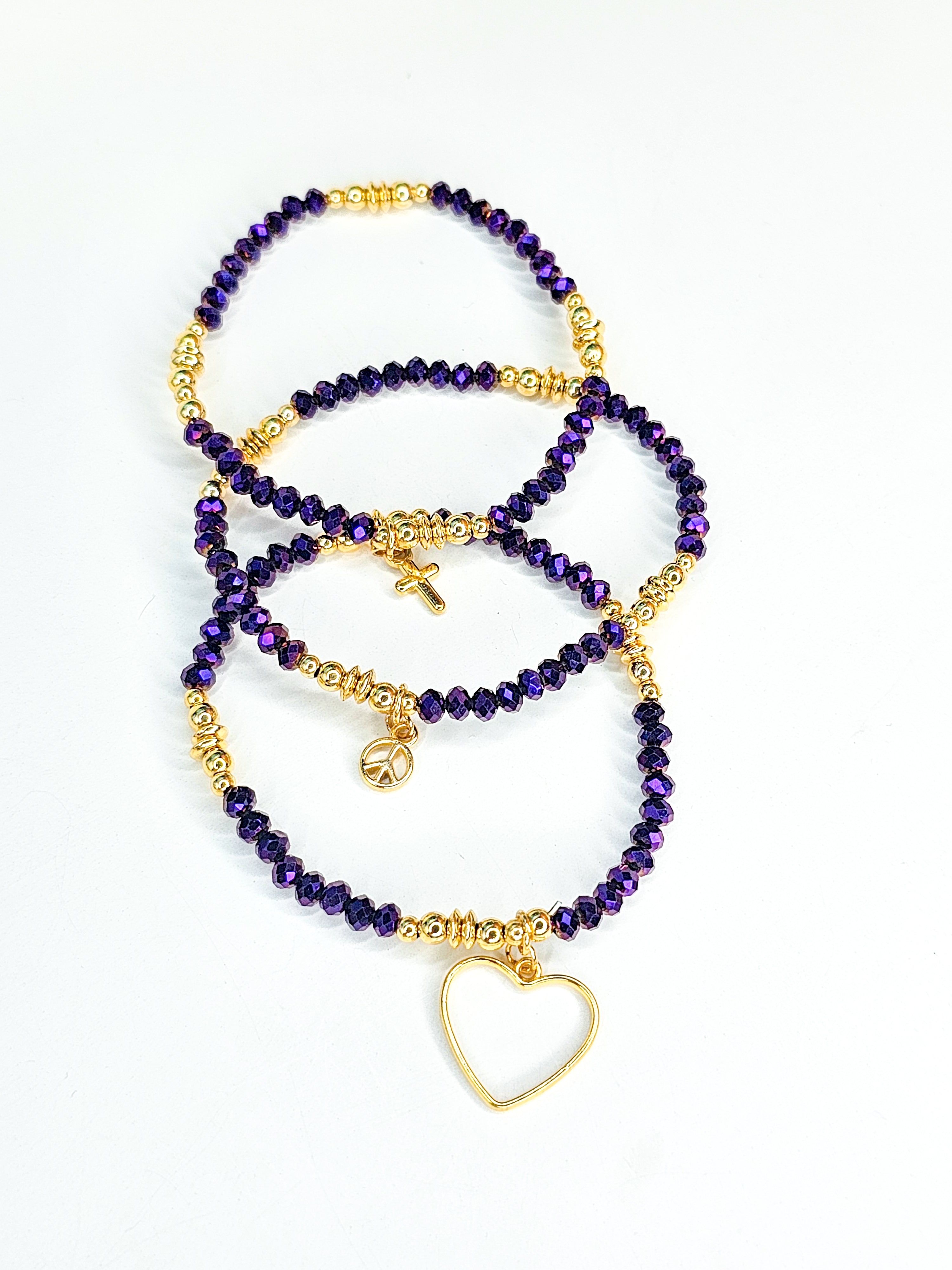 Set of purple beaded bracelets with gold accents 