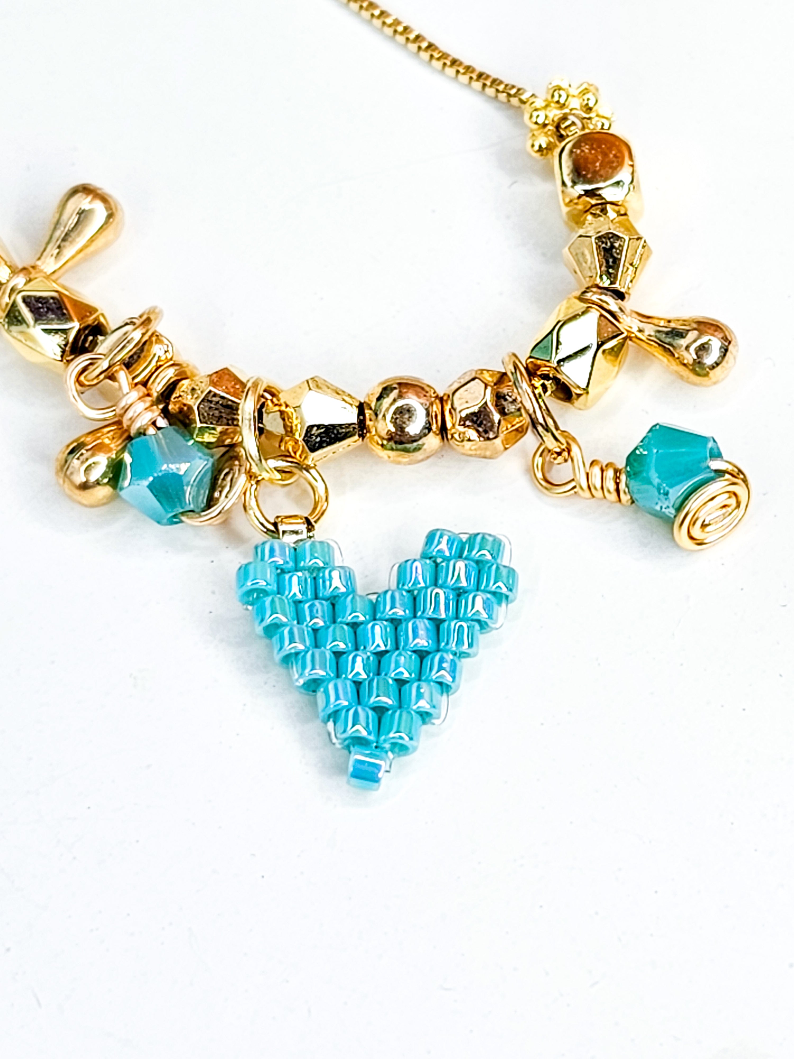Necklace with a gold chain and a turquoise heart-shaped charm