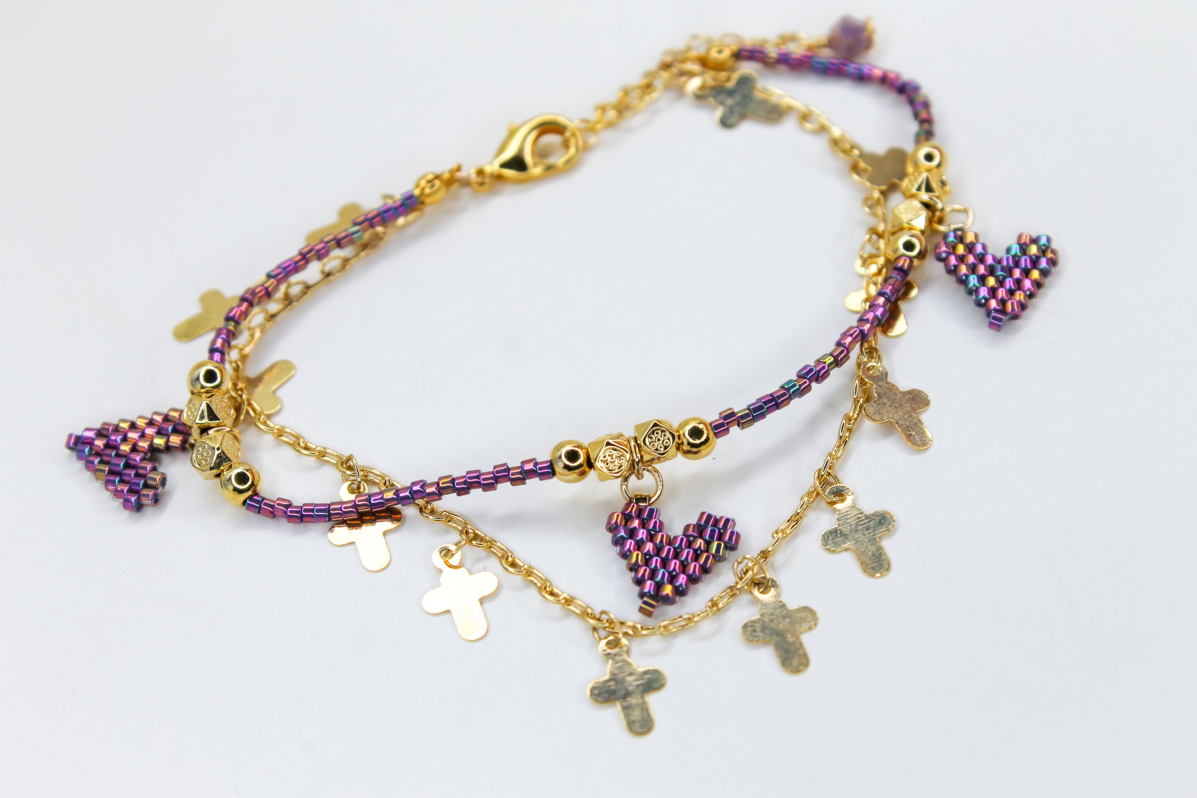 Gold and purple beaded bracelet with charms
